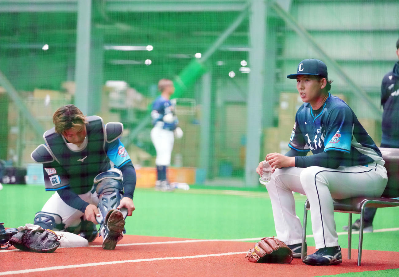 ライブBPの合間に椅子に座り休む西武武内。左は炭谷（撮影・横山健太）