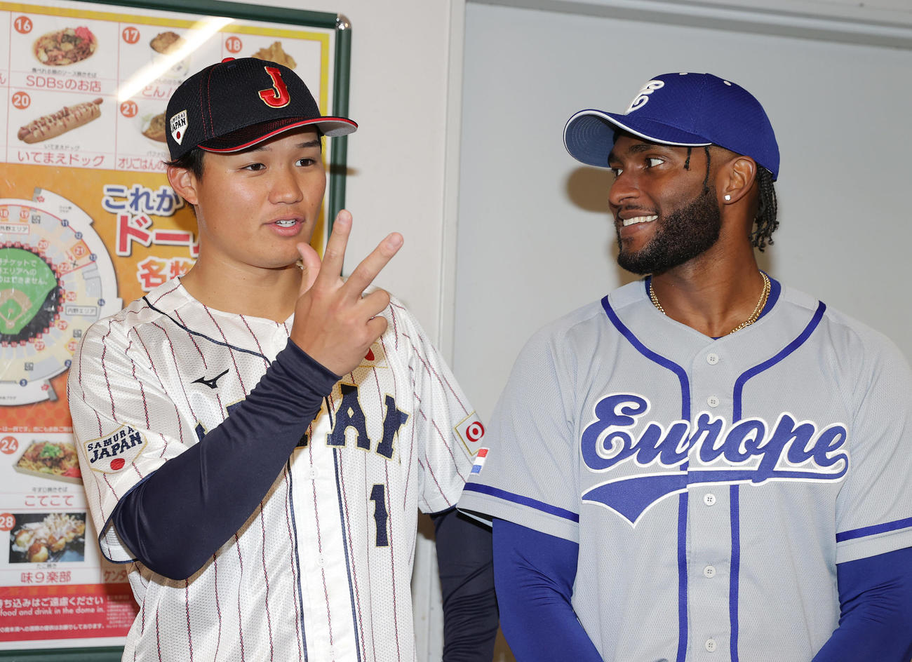 侍ジャパン対欧州代表　試合前、能登半島地震の被災地支援を目的とした募金活動で欧州代表の選手（右）と談笑する森下（撮影・前田充）