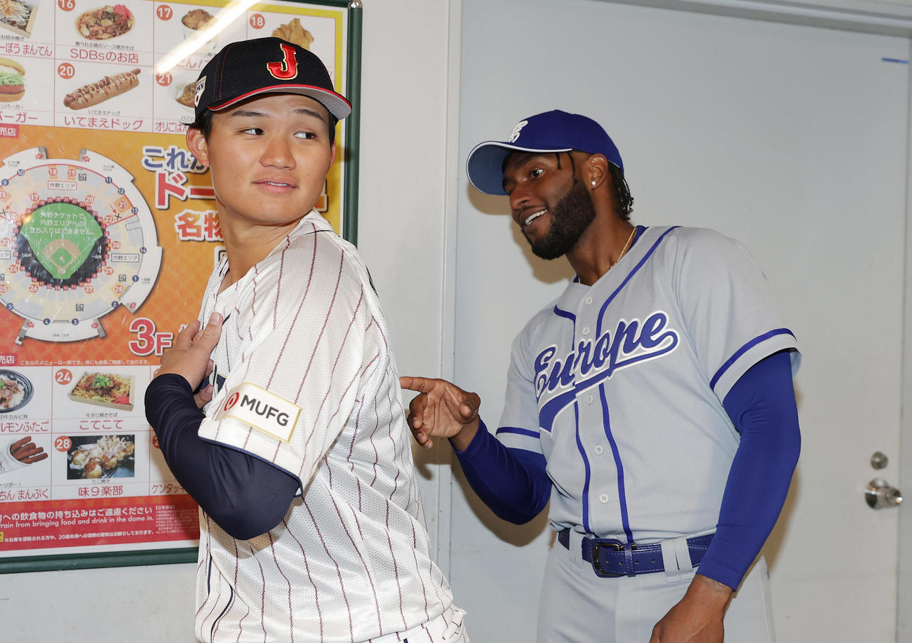 侍ジャパン対欧州代表　試合前、能登半島地震の被災地支援を目的とした募金活動で欧州代表の選手（右）と談笑する森下（撮影・前田充）