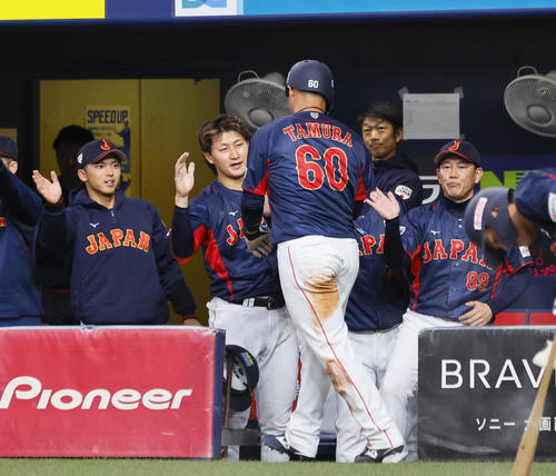欧州対日本 2回表日本1死一、三塁、山本の中犠飛で生還した田村俊介を出迎える井端監督(右端)(撮影・藤尾明華)