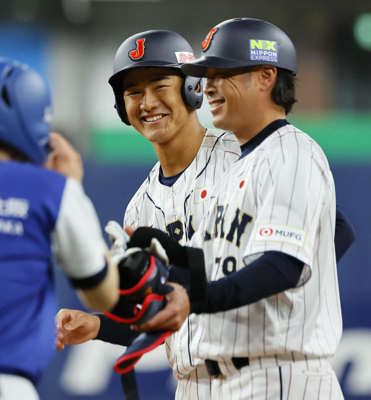 日本対欧州　8回裏日本2死一塁、左前打を放ち笑顔の西川。手前は亀井コーチ（撮影・藤尾明華）