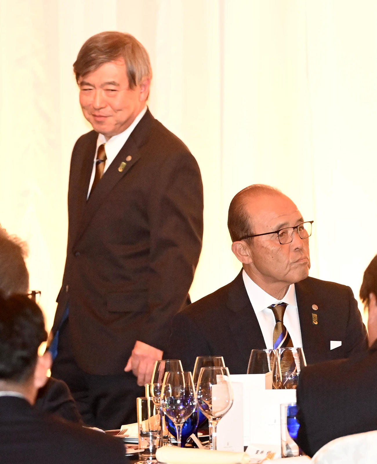 阪神タイガース激励会でのあいさつを終え席の戻る杉山オーナー（左）。右は岡田監督（撮影・前岡正明）