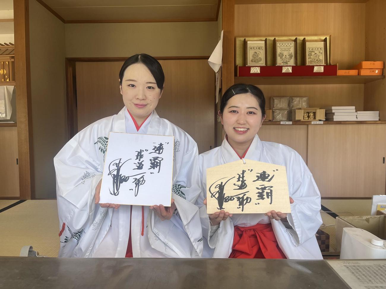 阪神岡田監督が書いた絵馬と色紙を手にする西宮神社の巫女さん（撮影・磯綾乃）