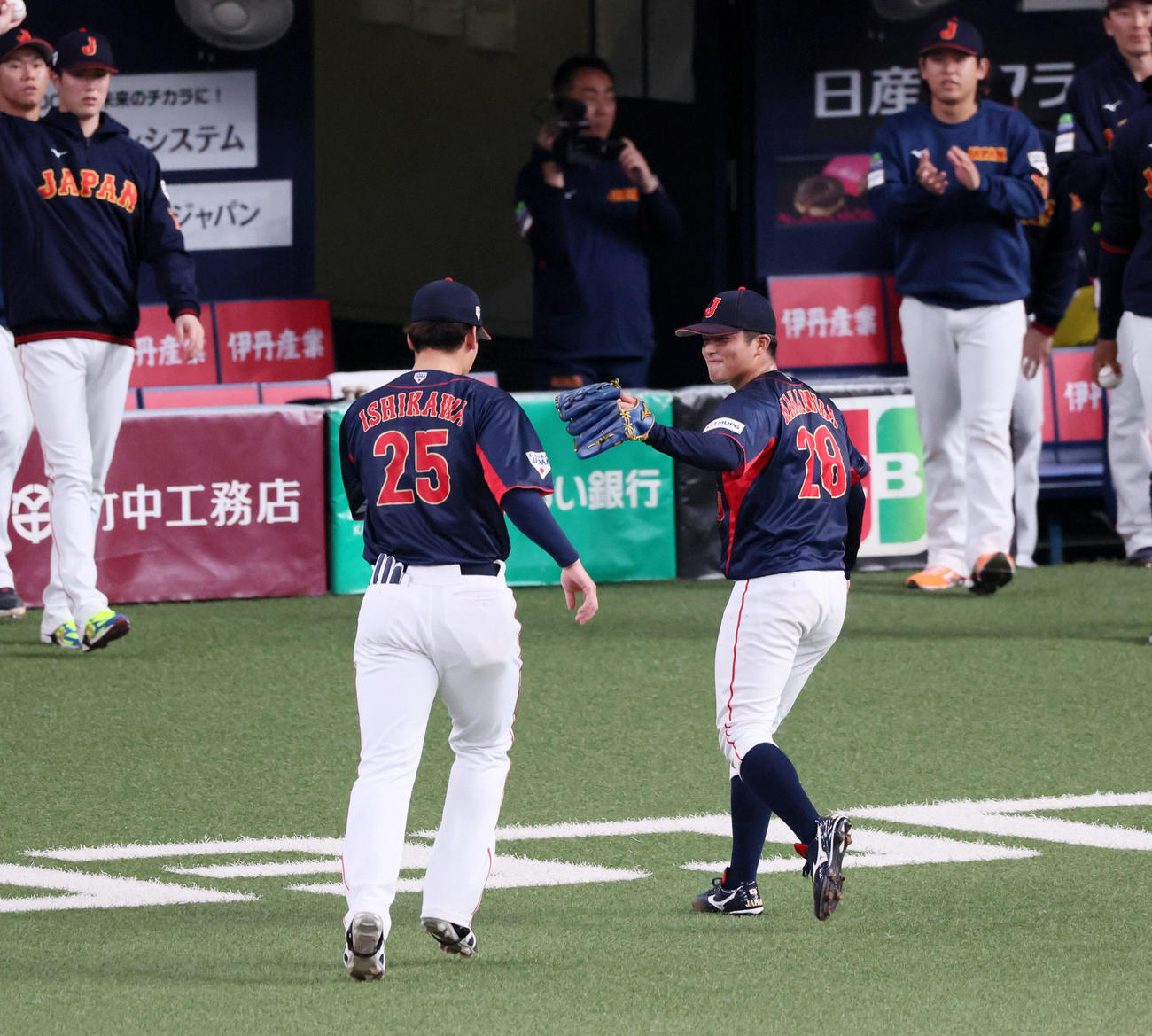 欧州対日本　3回裏に日本2番手で登板し無失点ピッチングを披露した中村（右）は石川昂と笑顔でタッチ（撮影・加藤哉）