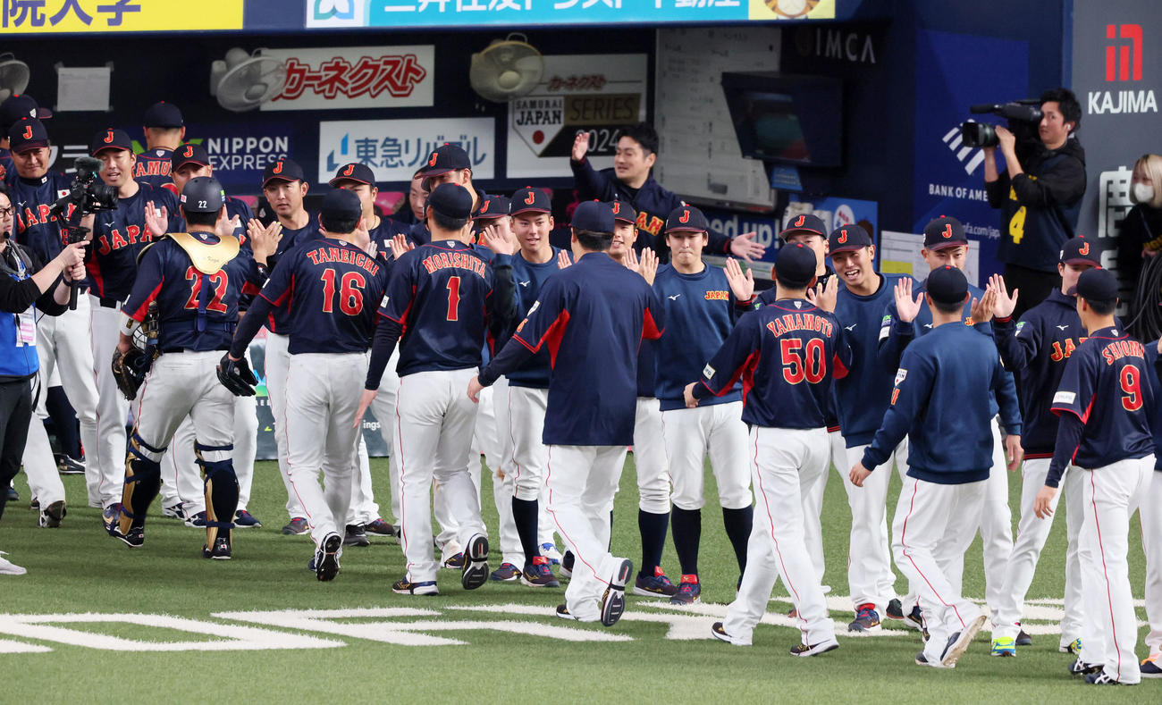 欧州対日本　欧州に勝利しナインを出迎えてタッチする金丸（撮影・加藤哉）
