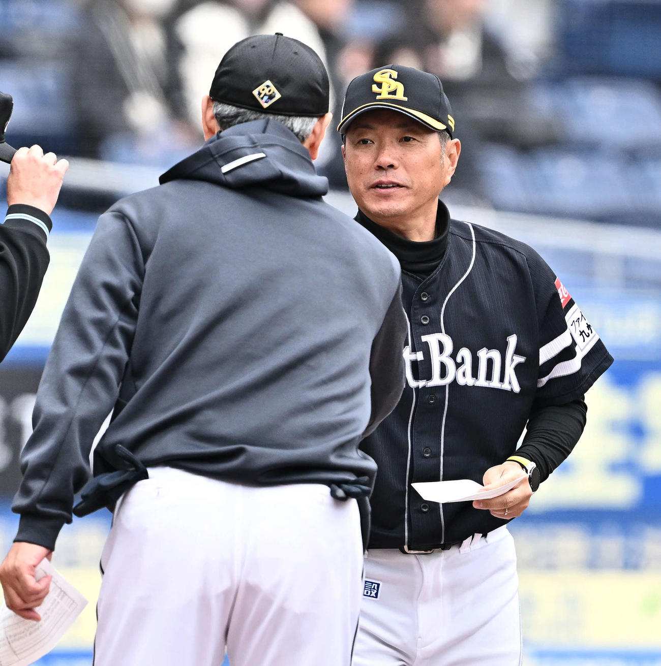 ロッテ対ソフトバンク　メンバー表の交換をするソフトバンク小久保監督（後方）とロッテ吉井監督（撮影・滝沢徹郎）
