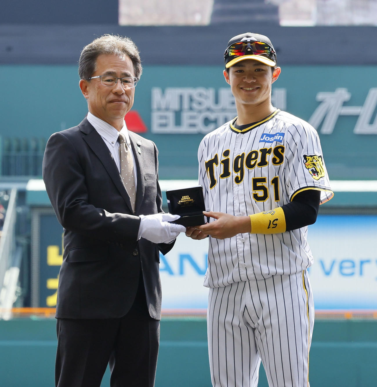 阪神対巨人　粟井一夫社長（左）からチャンピオンリングを贈られ笑顔を見せる阪神中野（撮影・藤尾明華）