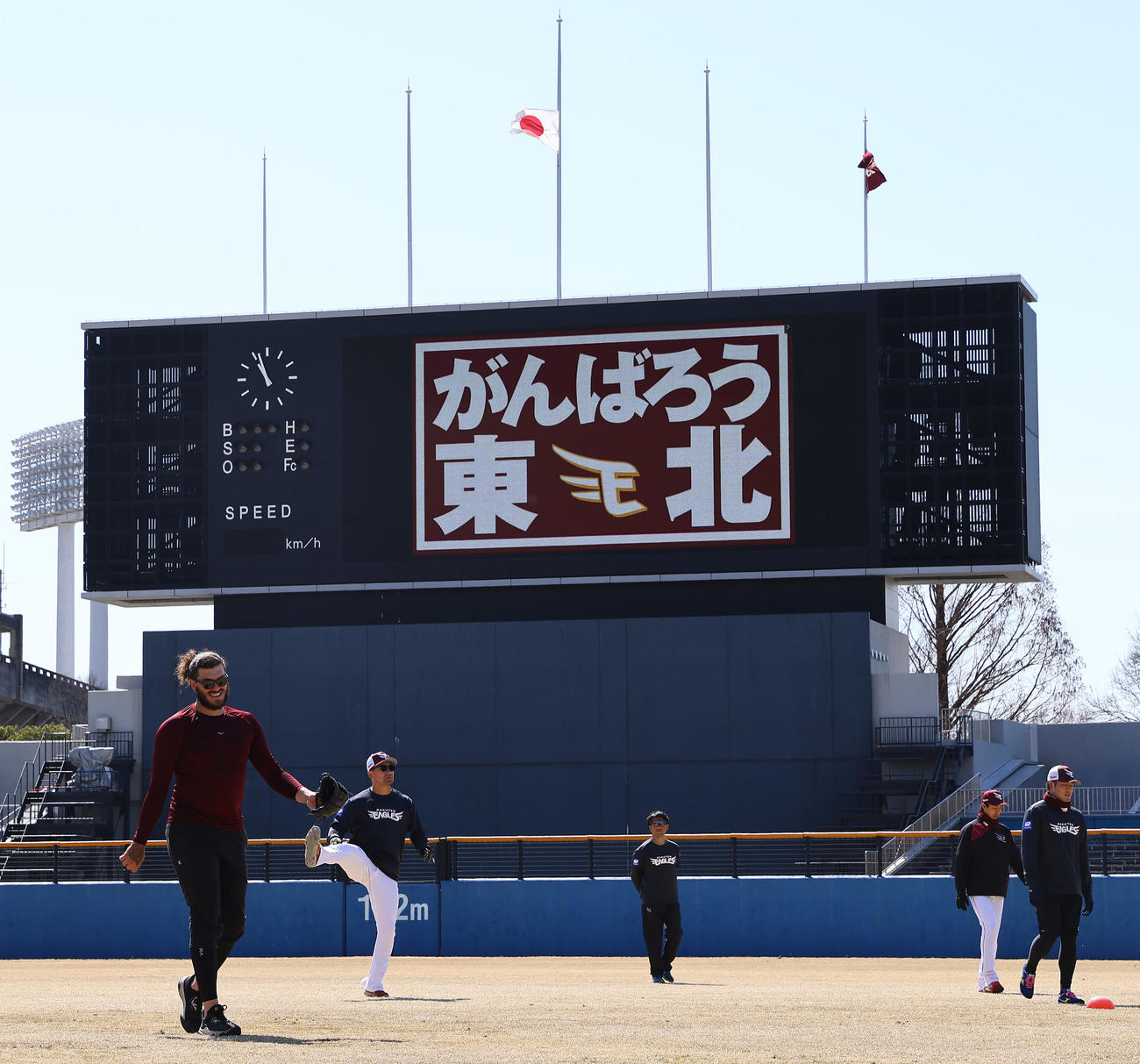 半旗が掲げられる球場で練習に臨む楽天投手陣（撮影・垰建太）