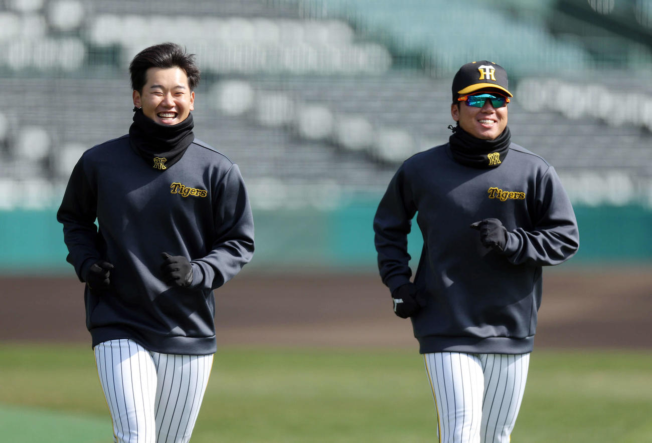 言葉を交わしながら笑顔でランニングする阪神門別（左）と村上（撮影・前田充）