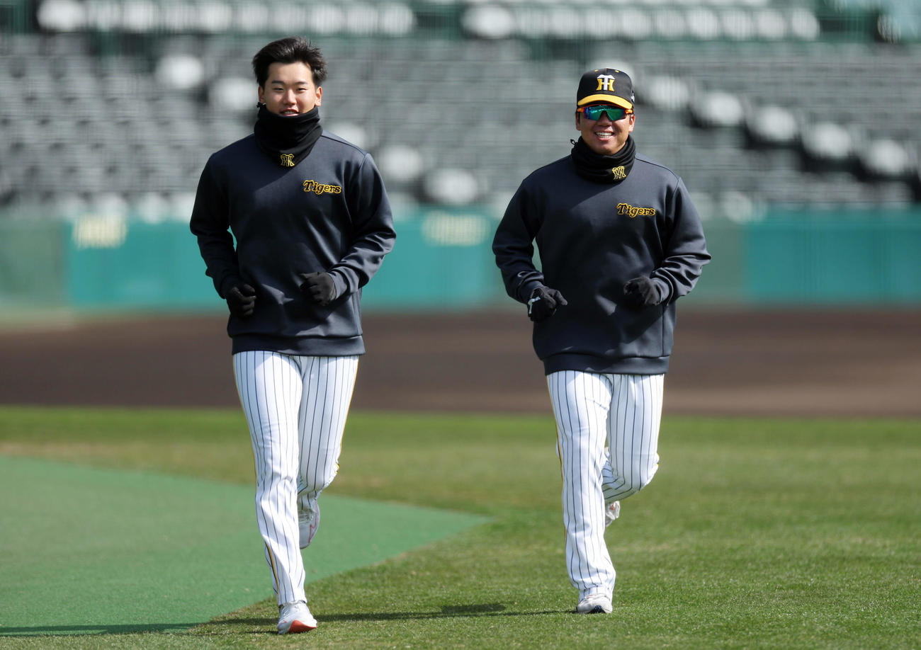 言葉を交わしながら笑顔でランニングする阪神門別（左）と村上（撮影・前田充）