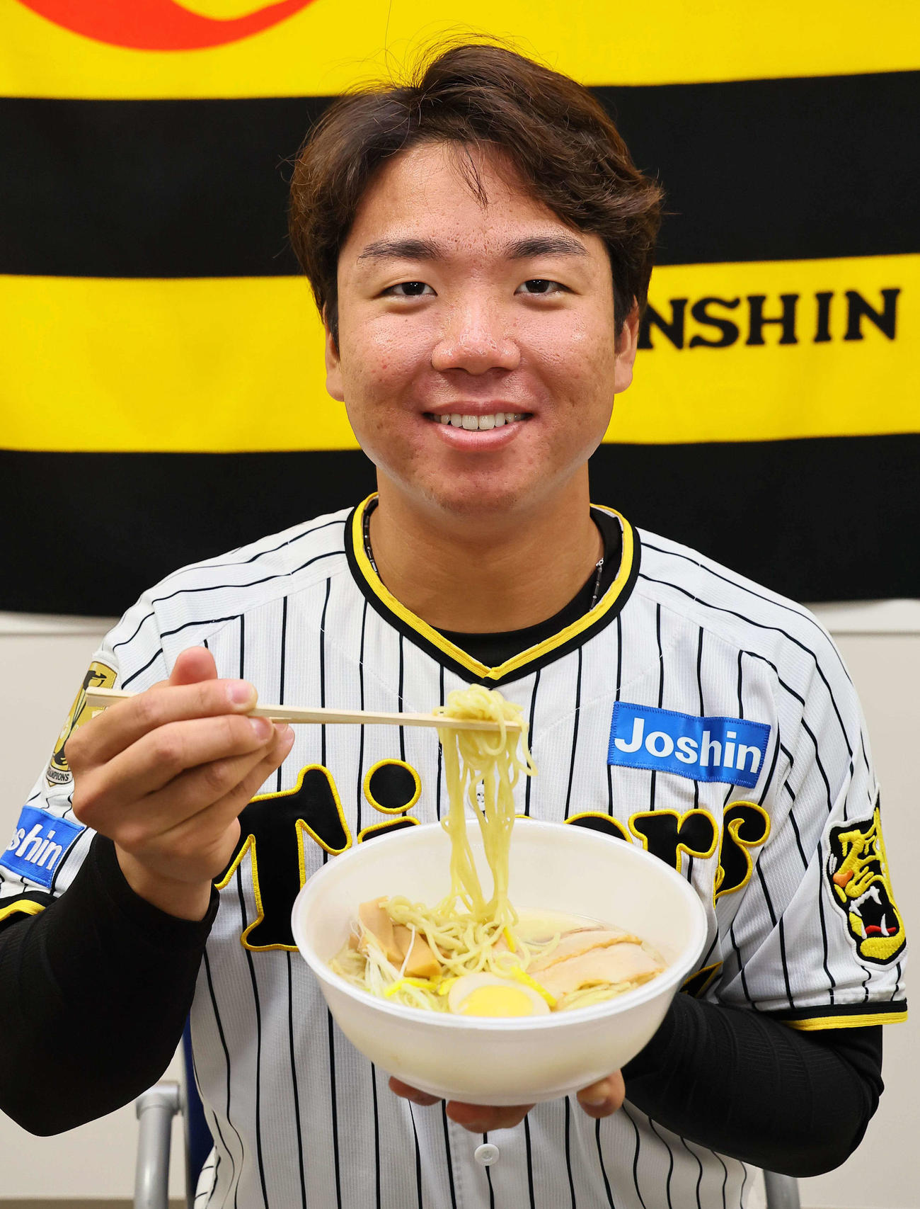 2024年監督・選手コラボグルメの新作「ラオタ村上の柚子香るさっぱり塩ラーメン」を手に笑顔を見せる村上（撮影・上田博志）