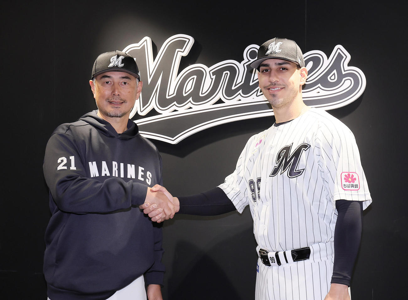 ロッテの入団会見に臨んだソト（右）は吉井監督と握手を交わす（撮影・足立雅史）