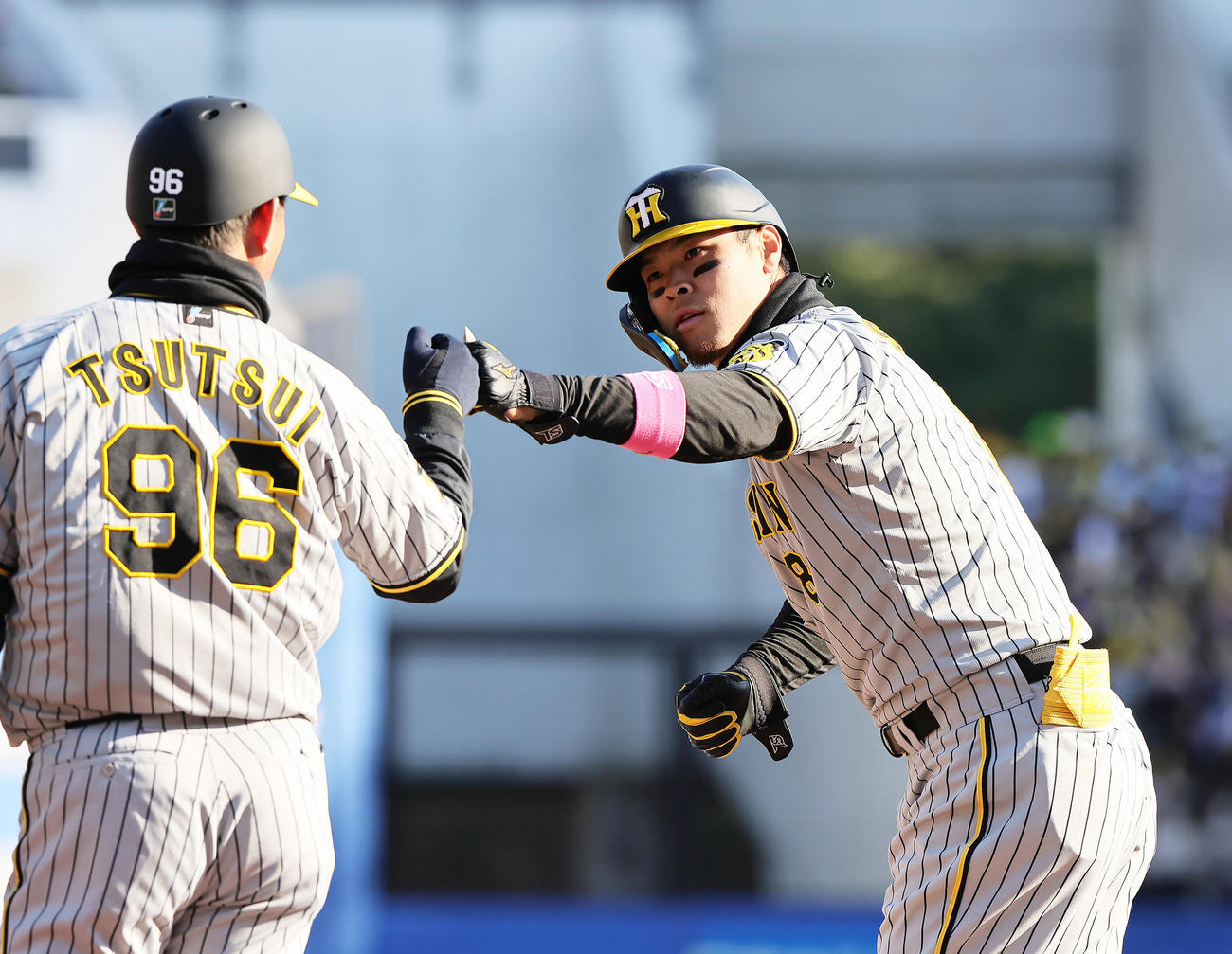 ロッテ対阪神　9回表阪神2死満塁、中前適時打を放ちタッチを交わす佐藤輝（撮影・足立雅史）