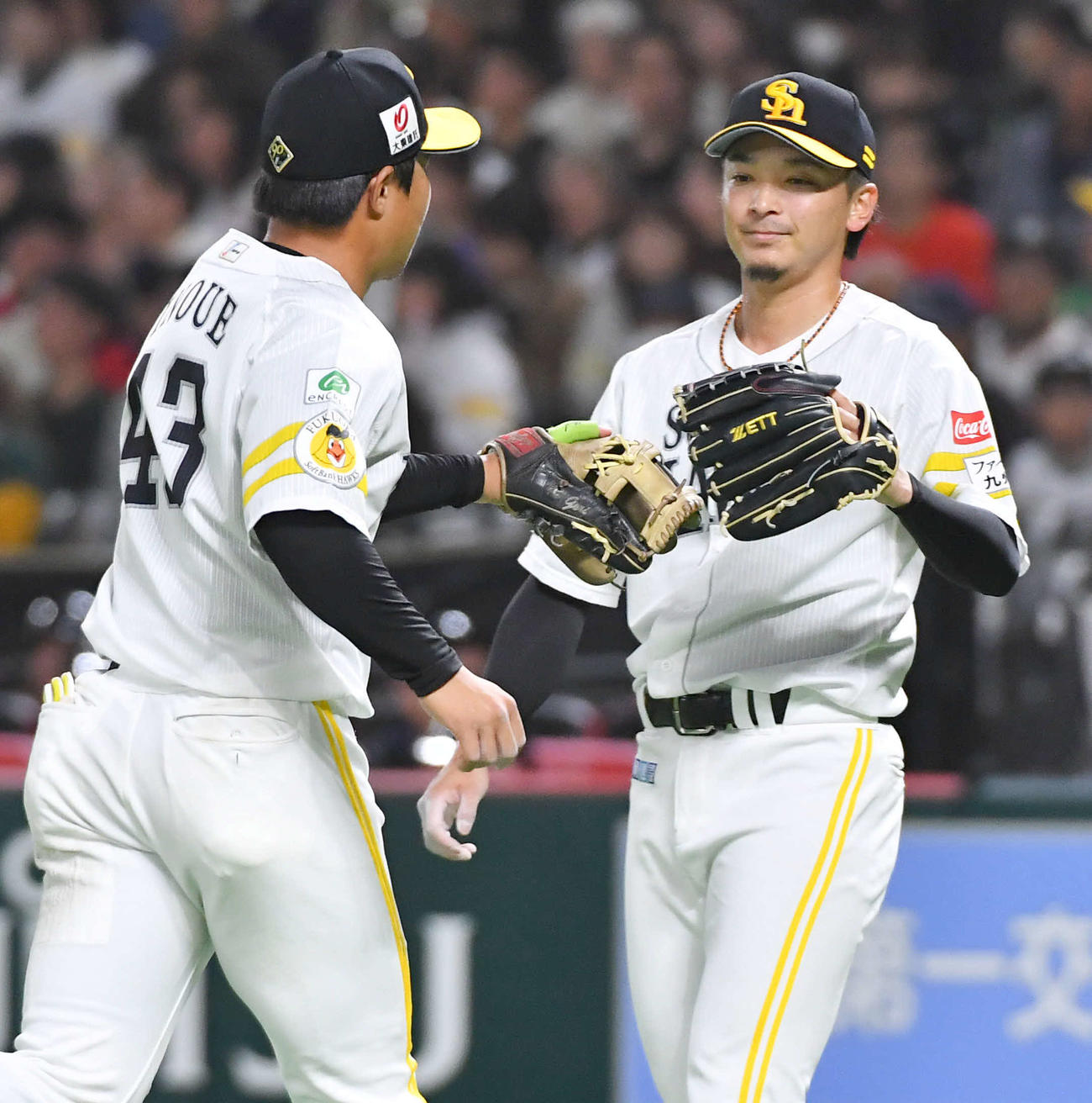 ソフトバンク対巨人　3回表巨人2死、松原の三ゴロを好守した井上（左）とグラブタッチを交わす東浜（撮影・岩下翔太）