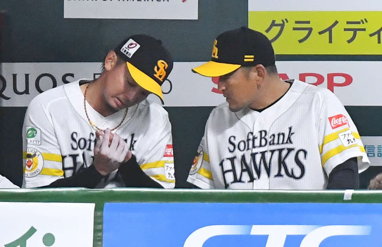 ソフトバンク対巨人　5回表終了後、ベンチで倉野コーチ（右）と指を気にしながら話す東浜（撮影・岩下翔太）