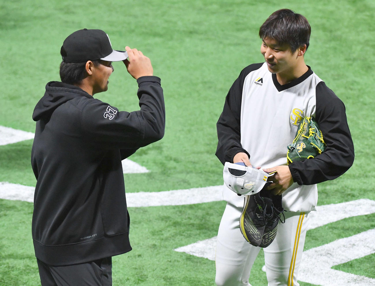 ソフトバンク対巨人　試合前、巨人郡（左）と話すソフトバンク長谷川（撮影・岩下翔太）