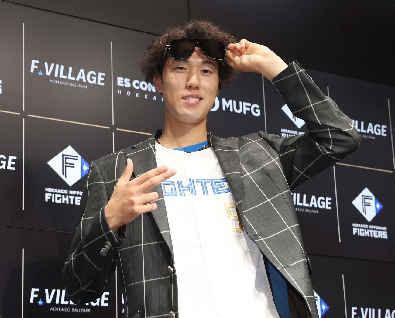支配下登録された福島は新庄監督からプレゼントされたスーツとサングラスを身に着けポーズをとる（撮影・黒川智章）