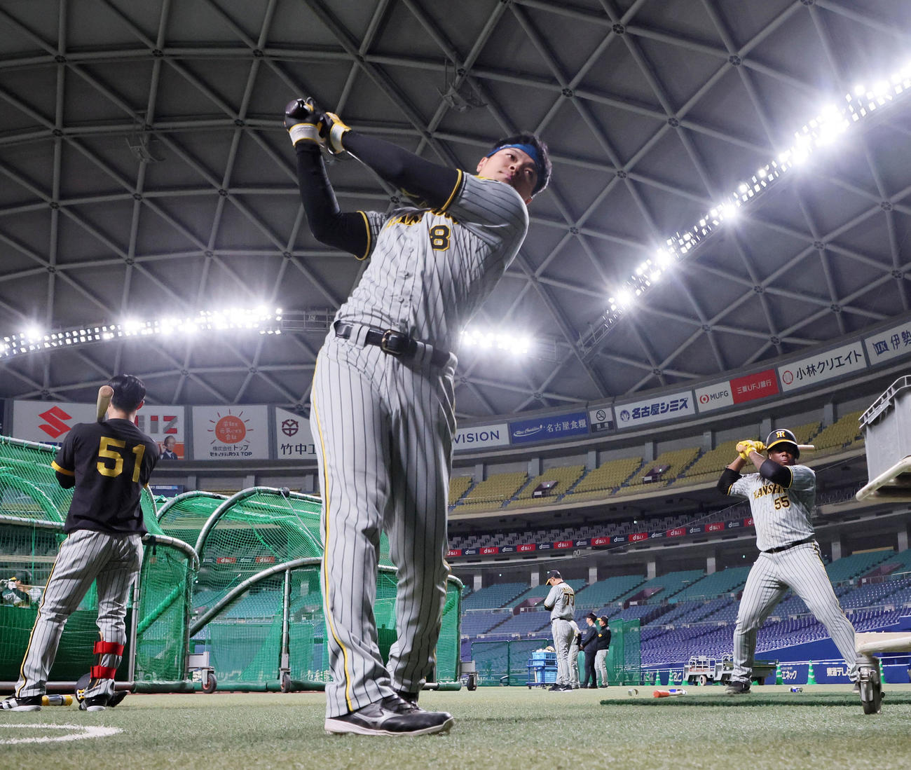 ティー打撃を行う前にネット裏に向かって素振りする佐藤輝（撮影・加藤哉）