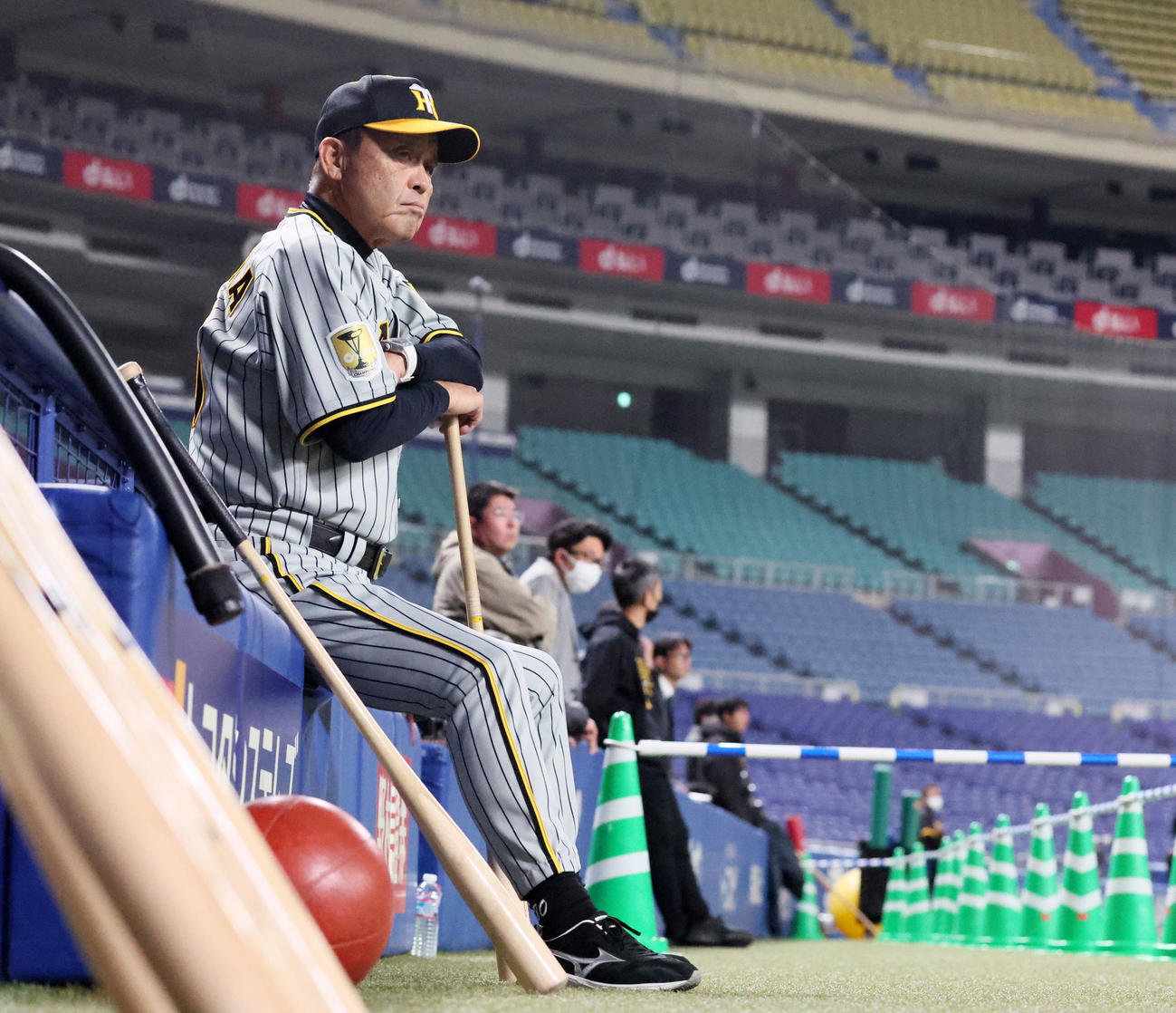 ベンチ前に腰を下ろして練習を見る岡田監督（撮影・加藤哉）