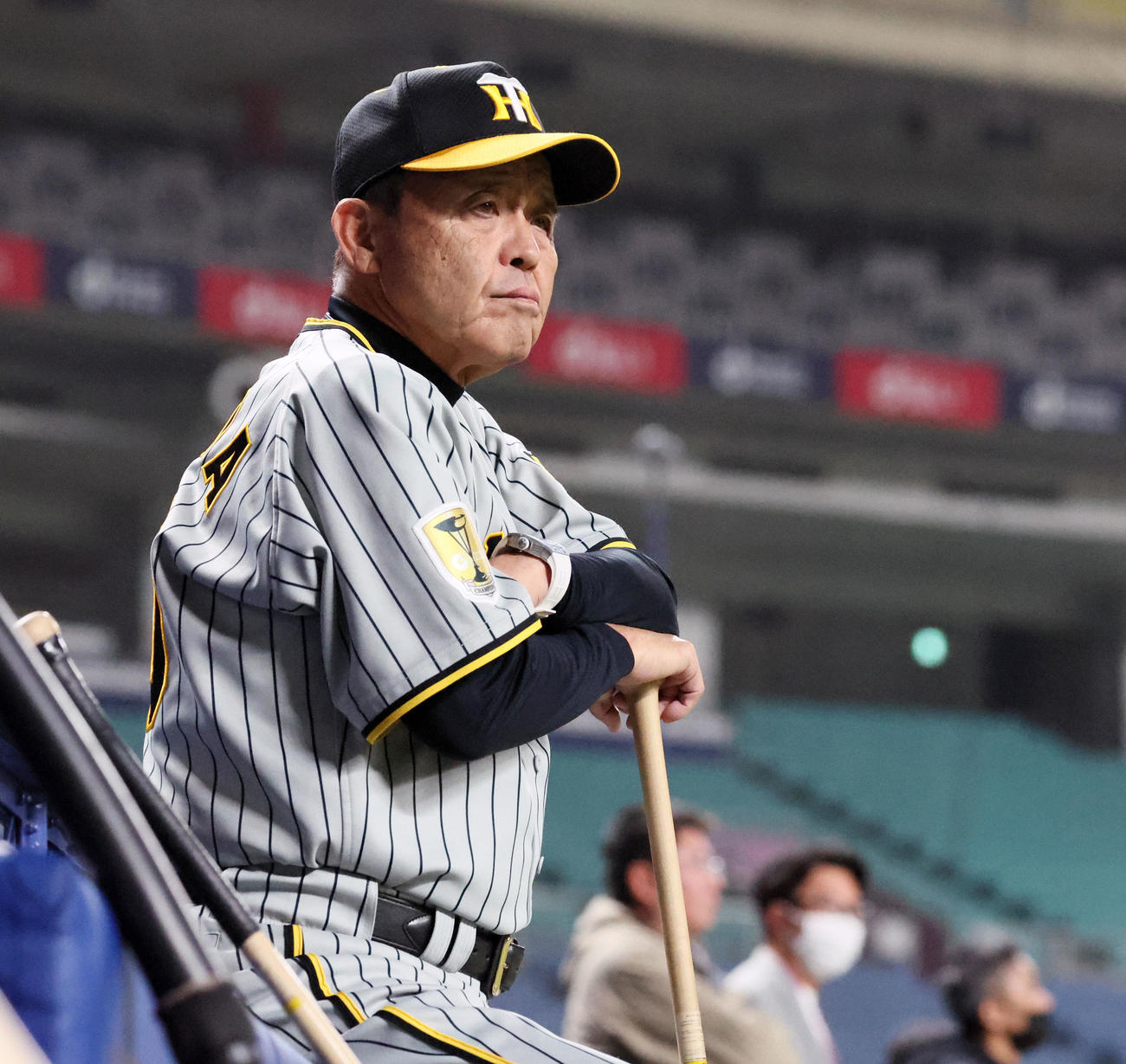 ベンチ前に腰を下ろして練習を見る岡田監督（撮影・加藤哉）