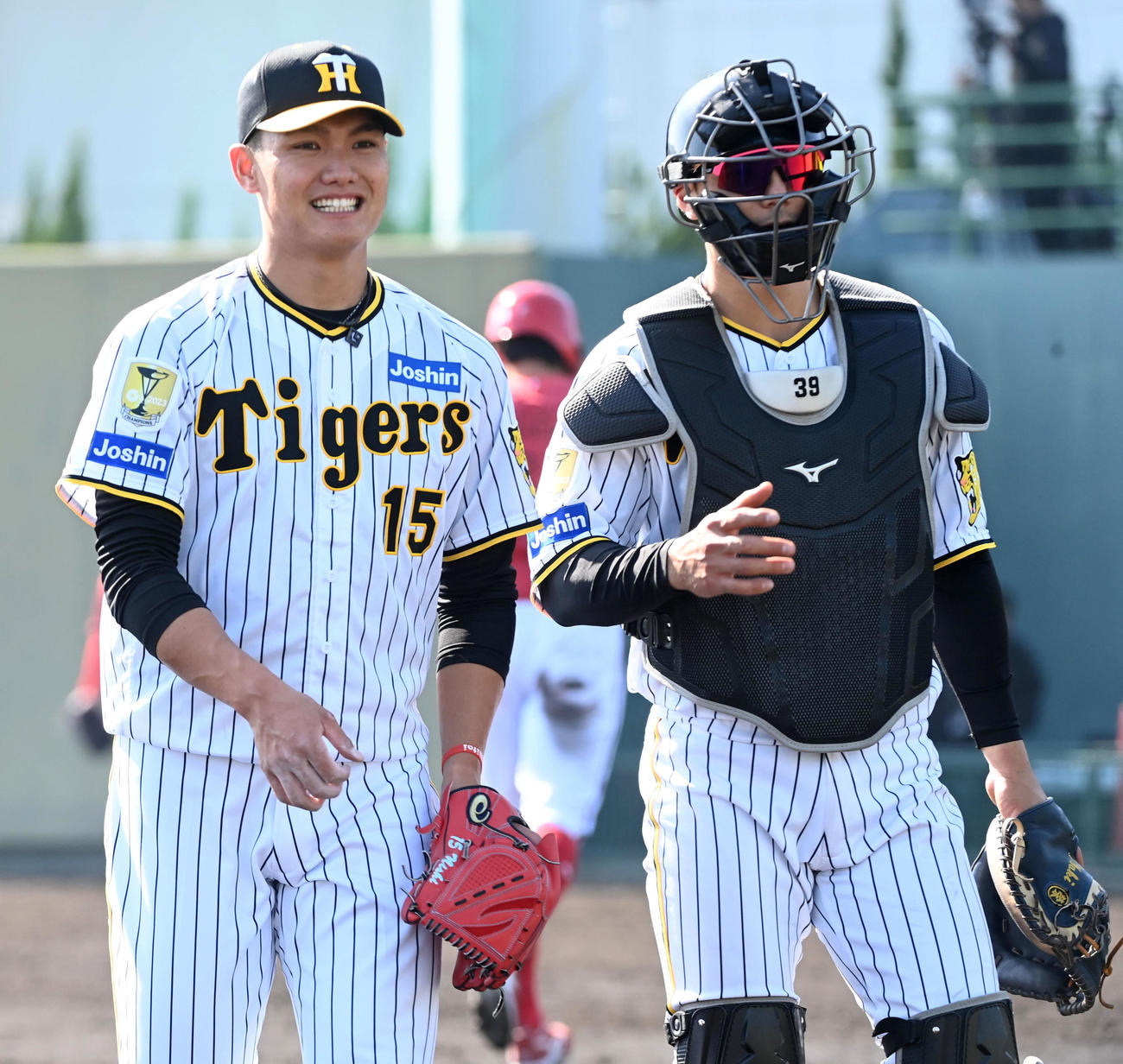 阪神対広島　6回、栄枝（右）と笑顔で話しながらベンチに戻る阪神2番手の西純（撮影・前岡正明）