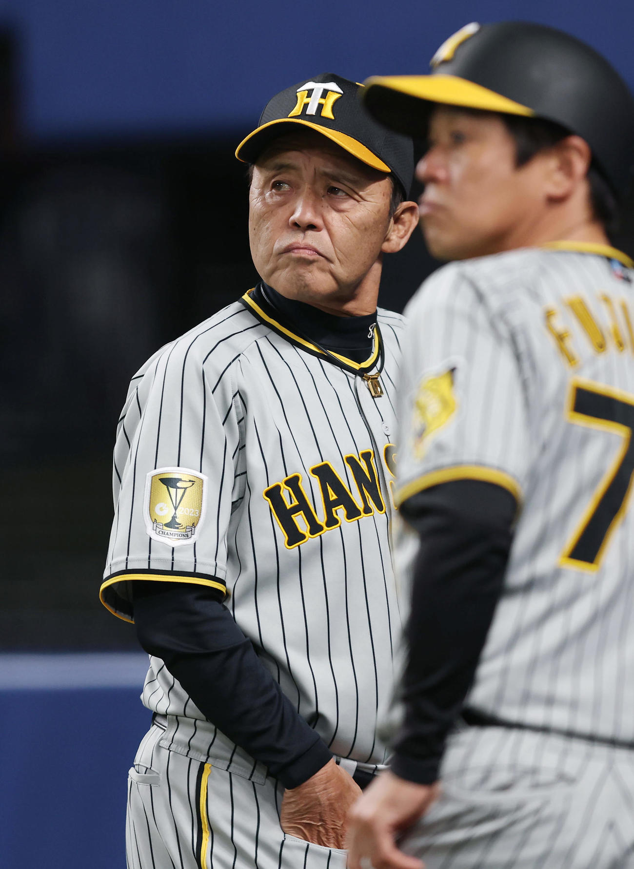 中日対阪神　7回表を終え選手交代を告げ厳しい表情でベンチへ戻る阪神岡田監督（撮影・前田充）