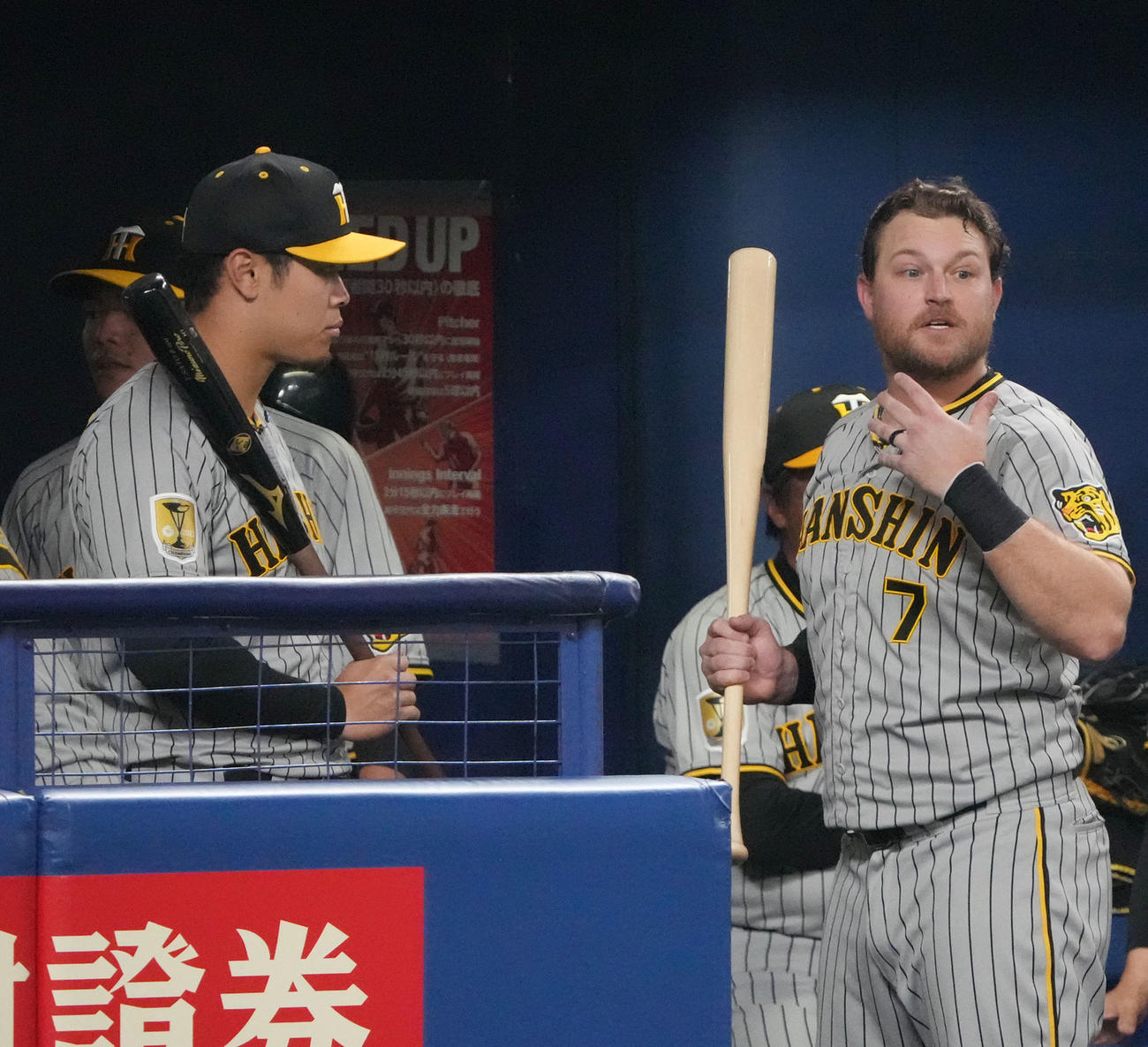 中日対阪神　6回表、ベンチでノイジー（右）のアドバイスを聞く佐藤輝（撮影・森本幸一）