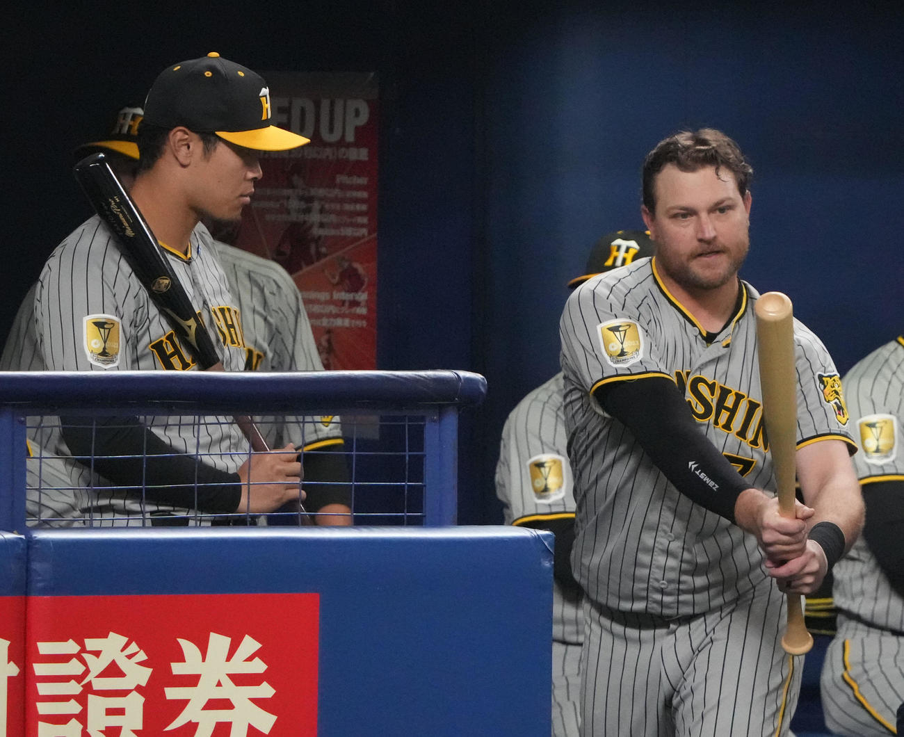中日対阪神　6回表、ベンチでノイジーにアドバイスを聞く佐藤輝（左）（撮影・森本幸一）