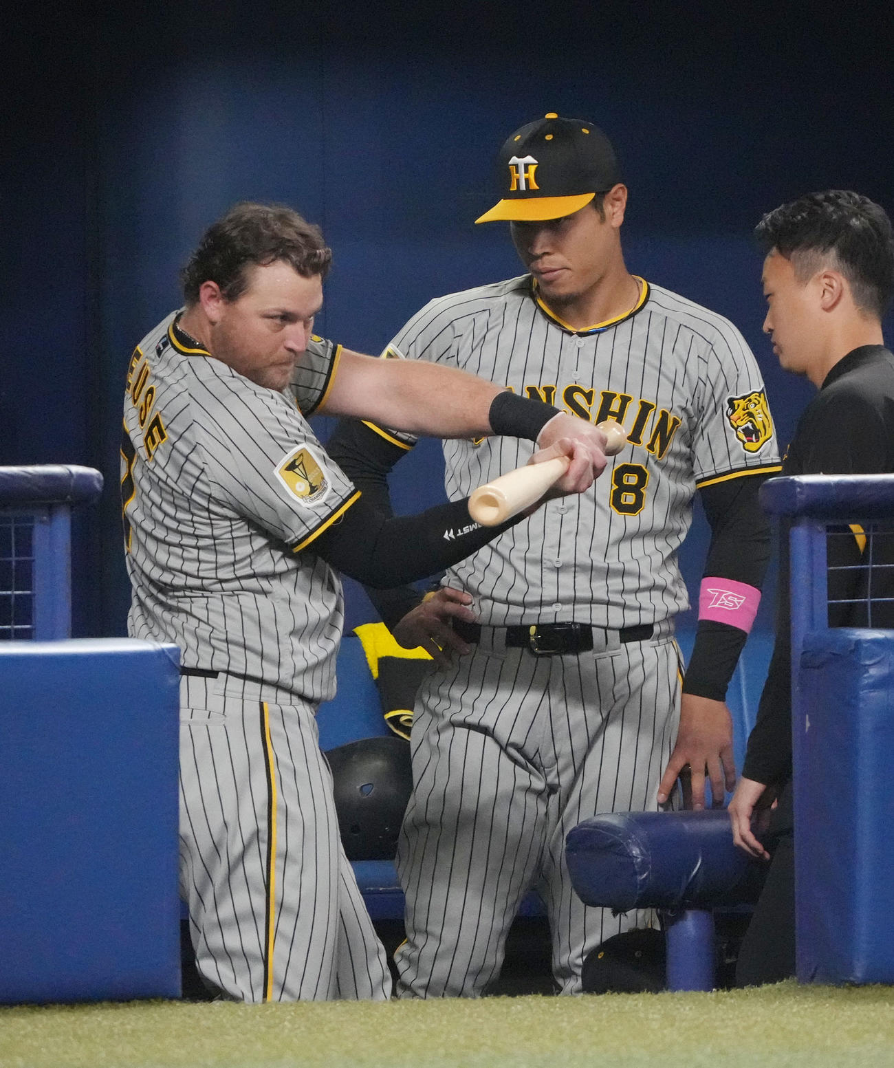 中日対阪神　6回裏、ベンチでノイジー（左）のアドバイスを聞く佐藤輝（撮影・森本幸一）