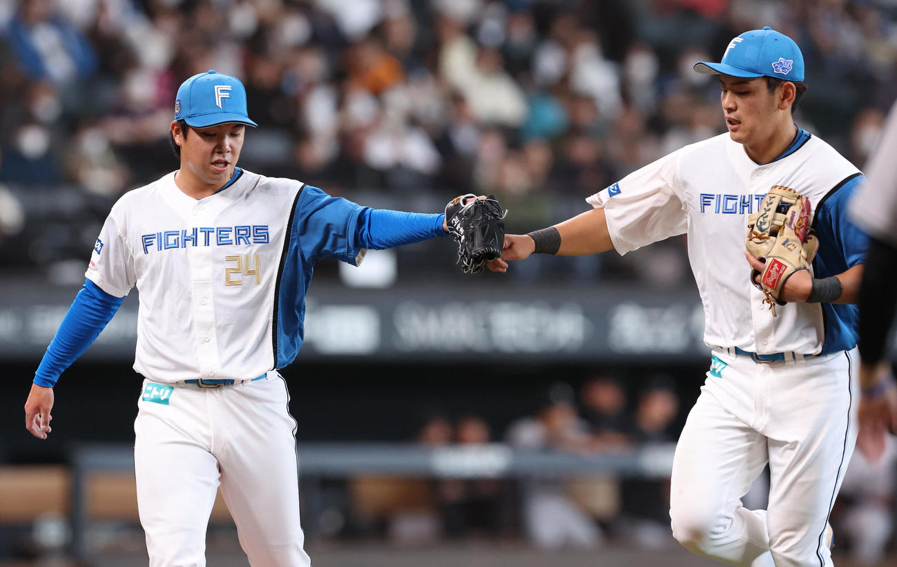日本ハム対巨人　8回表を無失点に抑えた金村（左）は野村とタッチしながらベンチに戻る（撮影・佐藤翔太）