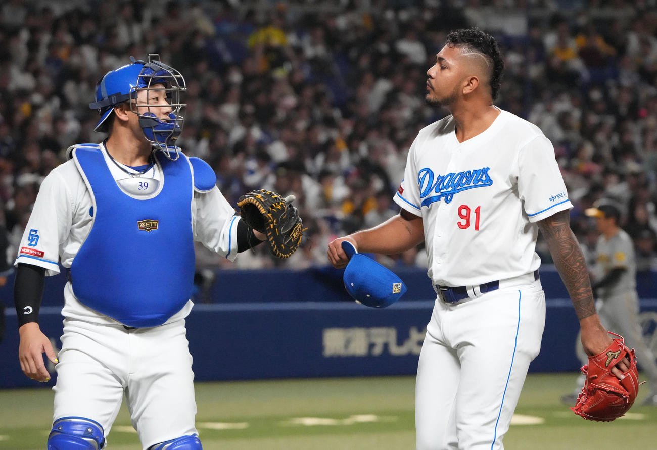 中日対阪神　1回表終了、宇佐見と言葉を交わしベンチへ戻る中日先発のメヒア（右）（撮影・森本幸一）