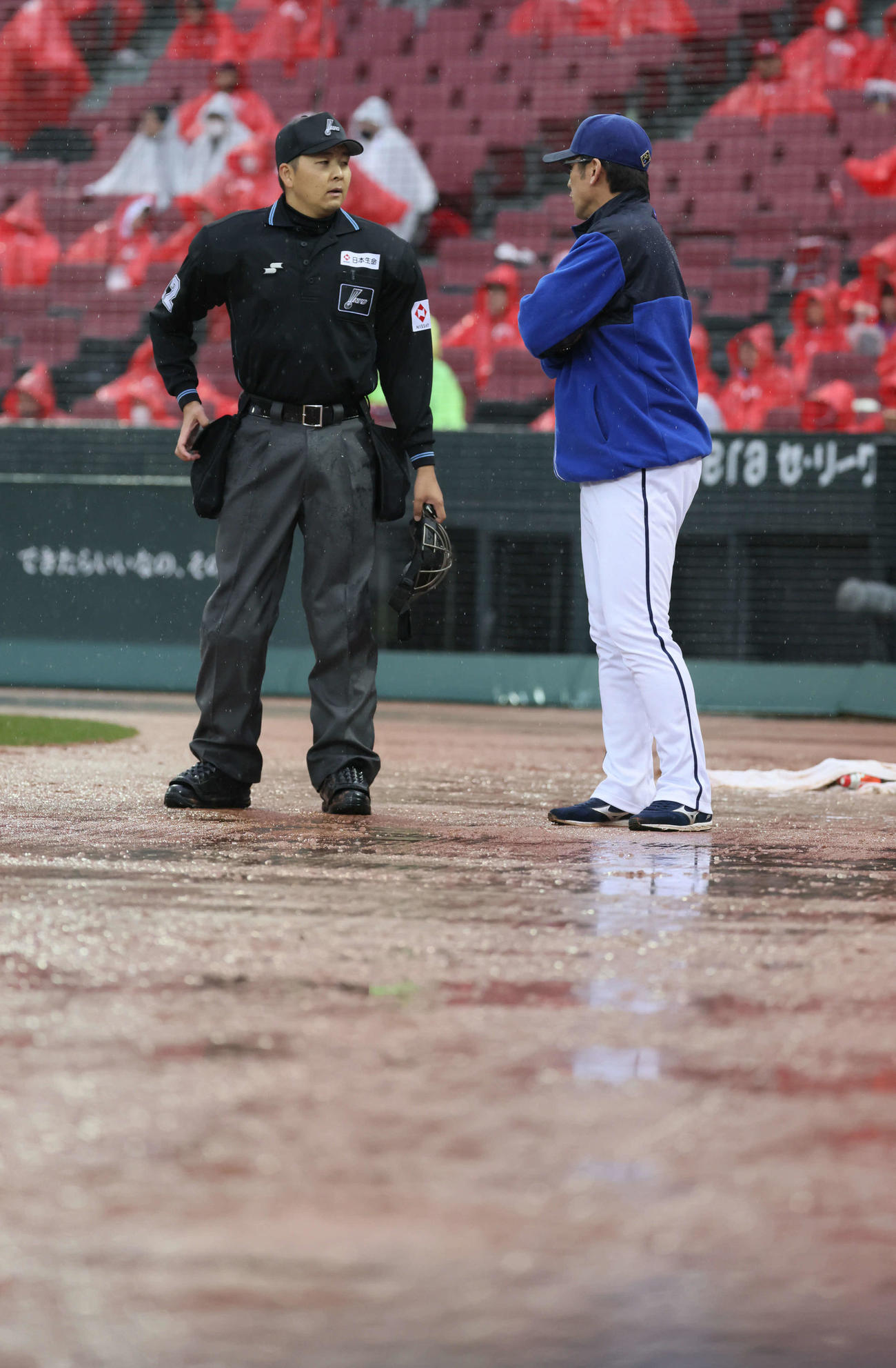 広島対DeNA 6回裏終了後、降雨のため試合が中断、審判と話し合うDeNA三浦監督（右）（撮影・加藤孝規）