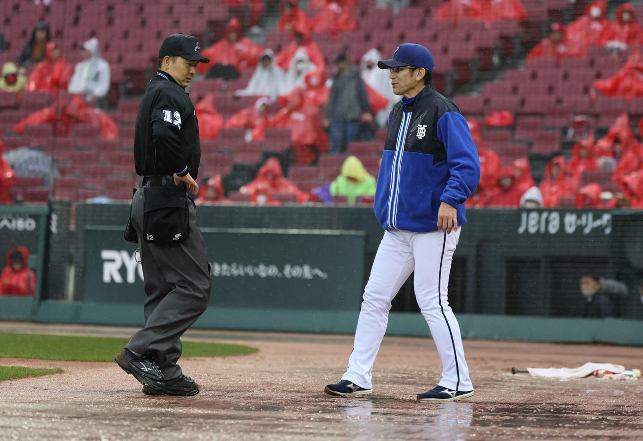 広島対DeNA 6回裏終了後、降雨のため試合が中断、審判と話し合うDeNA三浦監督（右）（撮影・加藤孝規）