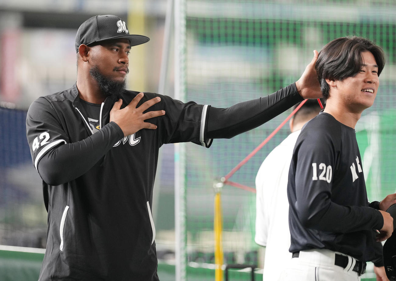 巨人対ロッテ　試合前練習で田中楓（右）に気付かれないようちょっかいを出すロッテ・メルセデス（撮影・鈴木みどり）