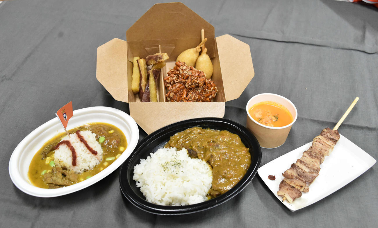 ハードオフ新潟で販売されるオイシックスのスタジアムグルメ。前列左から「必勝！Oisix新潟キッズカレー」（税込み600円）、新潟県産牛たっぷり燻製カレー（税込み900円）、幻の豚肉「鬼の宝ポーク」のジューシー豚串（税込み700円）、後列左から新潟を味わうフライグルメ3種盛り（税込み1000円）、アルビカラーのあったか濃厚にんじんポタージュ（税込み400円）