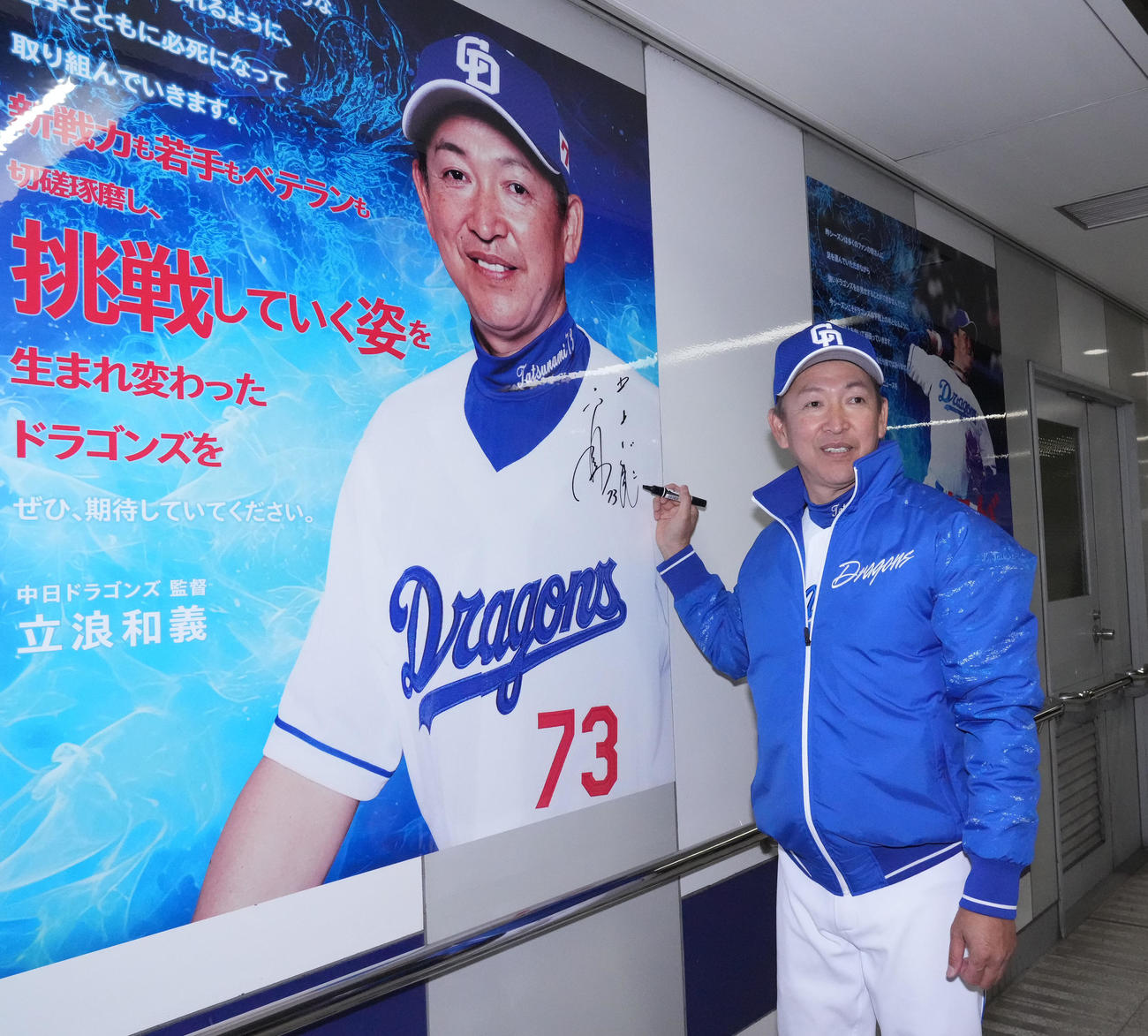 ドラゴンズロード2024お披露目セレモニーを終え、自身の写真にサインを記す立浪監督（撮影・森本幸一）