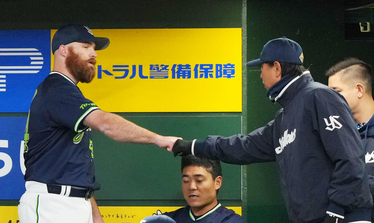 西武対ヤクルト　6回裏を無失点に抑えヤクルト伊藤コーチ（右）とタッチを交わすサイスニード（撮影・横山健太）