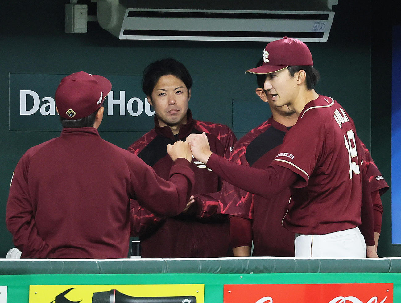巨人対楽天　4回途中無失点の楽天荘司（右）はベンチでコーチ陣らとタッチを交わす（撮影・足立雅史）