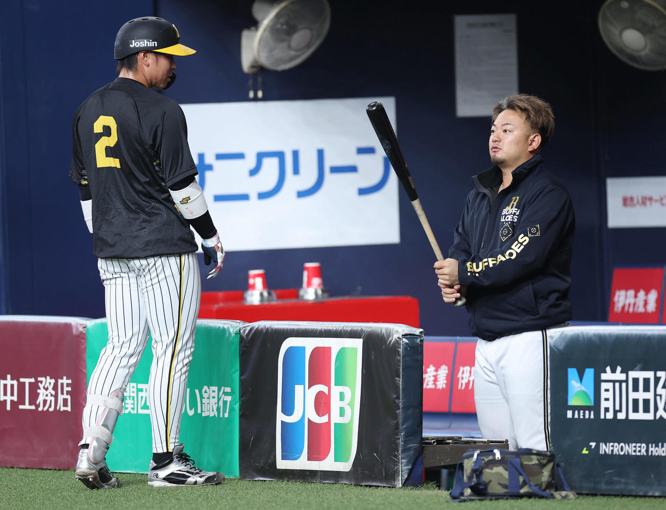 阪神対オリックス　阪神梅野（左）のバットを手に言葉を交わすオリックス森（撮影・前田充）