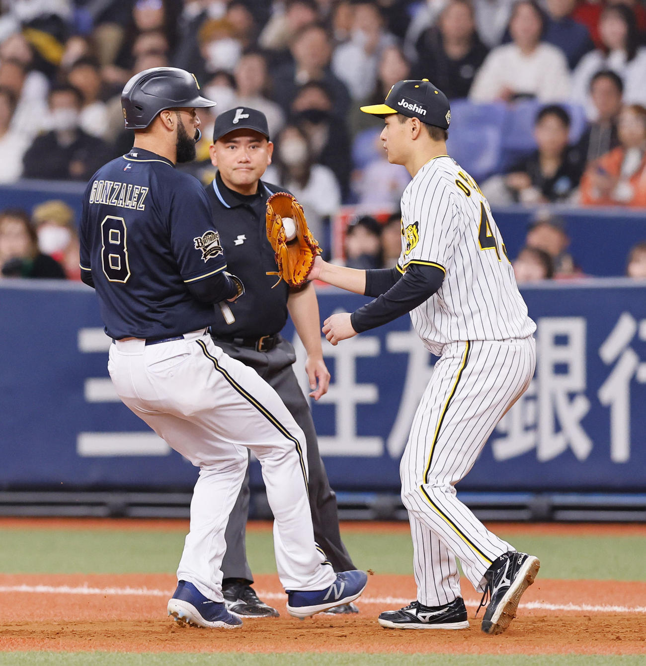 オリックス対阪神　4回裏阪神1死一、三塁、広岡の一ゴロ併殺で、挟まれたゴンザレス（左）にタッチする大竹（撮影・藤尾明華）
