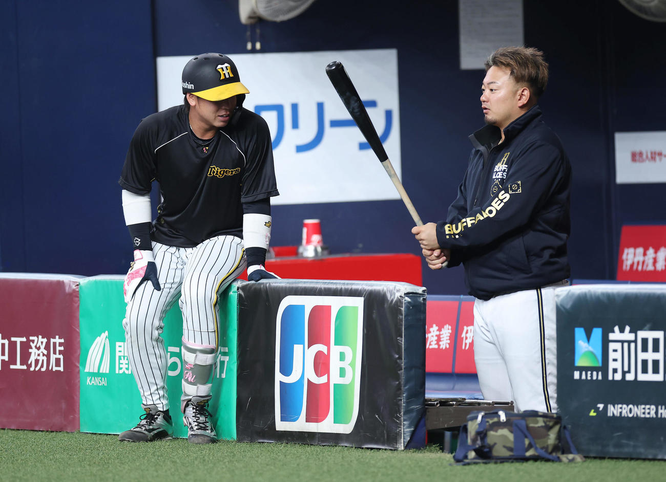 阪神対オリックス　阪神梅野（左）のバットを手に言葉を交わすオリックス森（撮影・前田充）