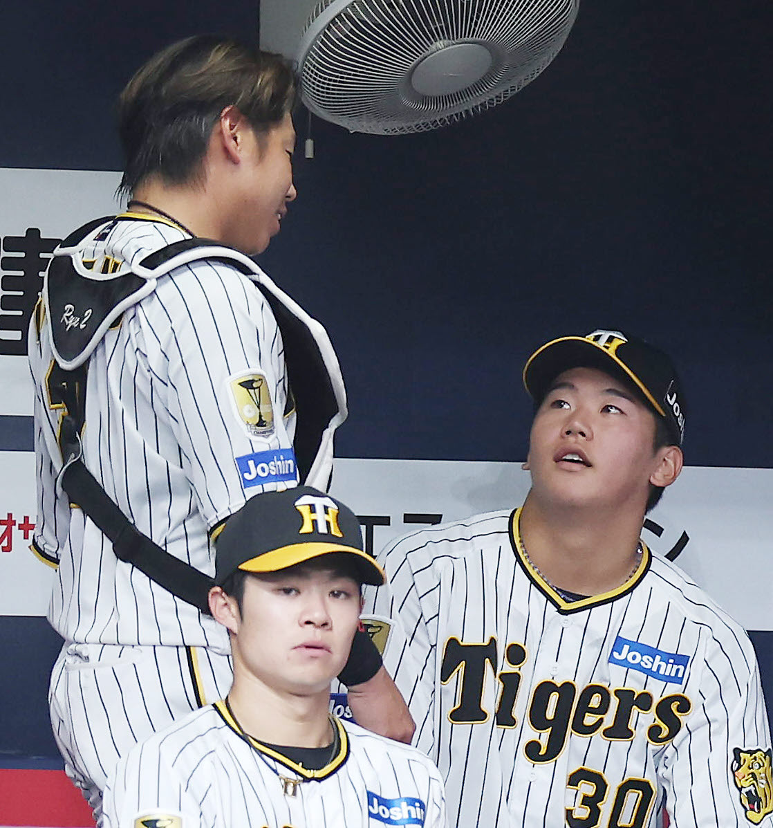 阪神対オリックス　回表を投げ終え、ベンチで阪神梅野（左）と言葉を交わす門別（撮影・前田充）