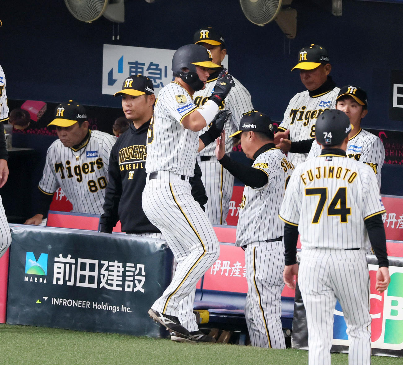 阪神対オリックス　1回裏、先制適時打を放った前川は攻守交代でベンチへ戻りナインとタッチ。左は岡田監督（撮影・加藤哉）