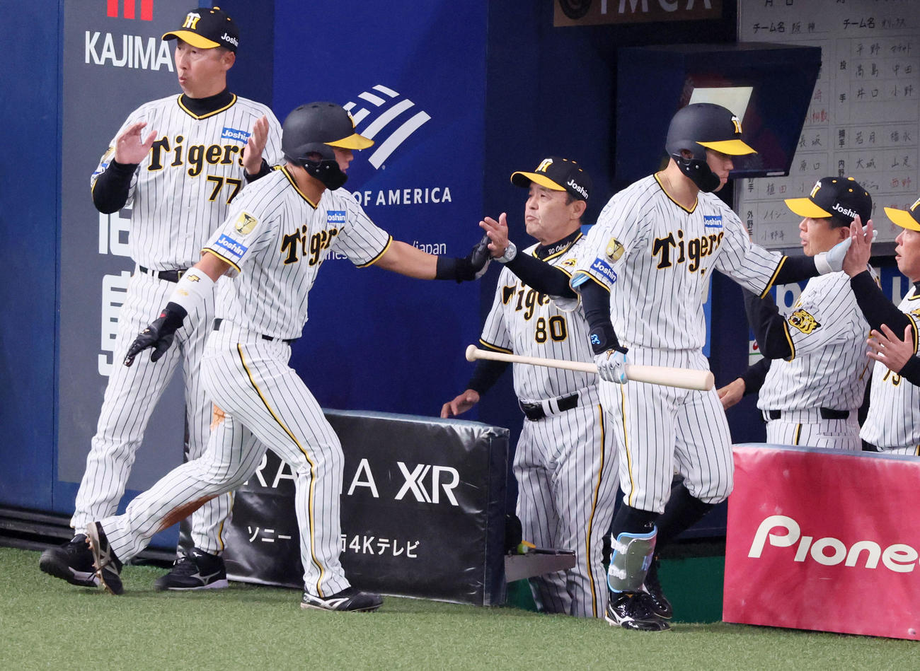阪神対オリックス　4回裏阪神1死三塁、三走前川（左）は糸原の中犠飛で生還しベンチの岡田監督とタッチ（撮影・加藤哉）