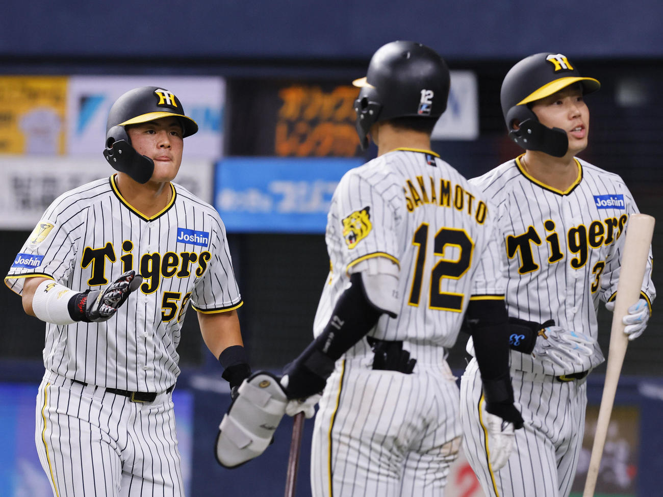 オリックス対阪神　4回裏阪神1死三塁、生還しナインに迎えられる前川（左）と犠飛を放った糸原（右）（撮影・藤尾明華）