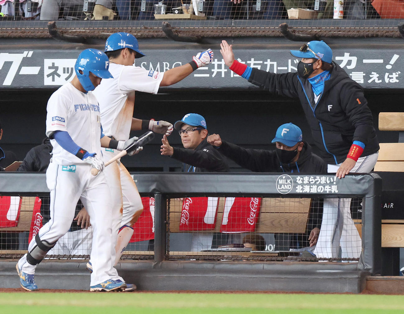 日本ハム対DeNA 8回裏日本ハム2死、中前打を放った野村（左）を出迎える新庄監督（撮影・佐藤翔太）