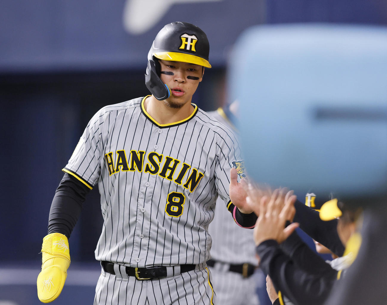 オリックス対阪神　2回表阪神無死一、二塁、原口の右前適時打で生還し、ベンチのナインとタッチを交わす佐藤輝（撮影・藤尾明華）