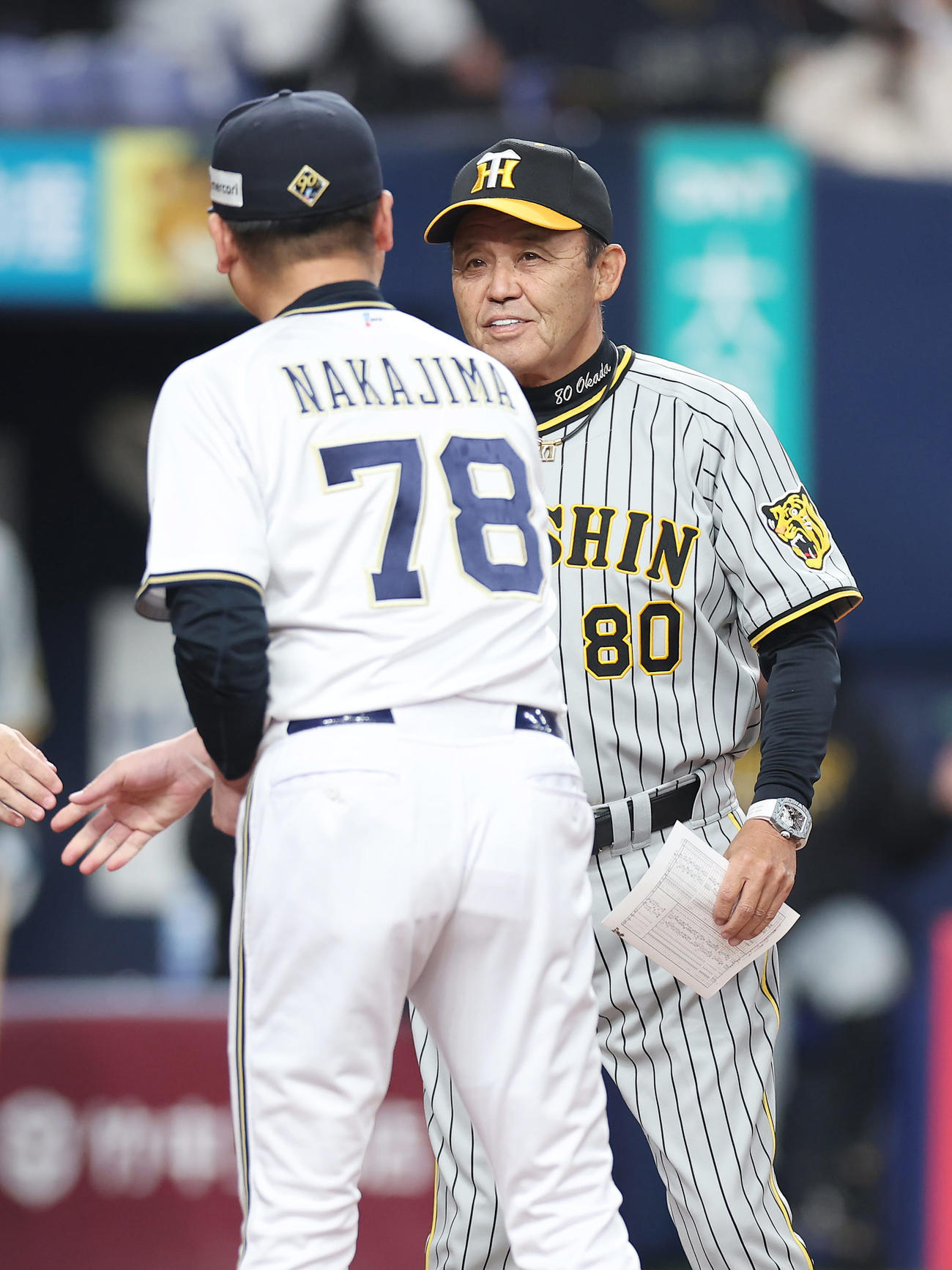オリックス対阪神　オリックス中嶋監督（左）とメンバー表を交換する阪神岡田監督（撮影・前田充）