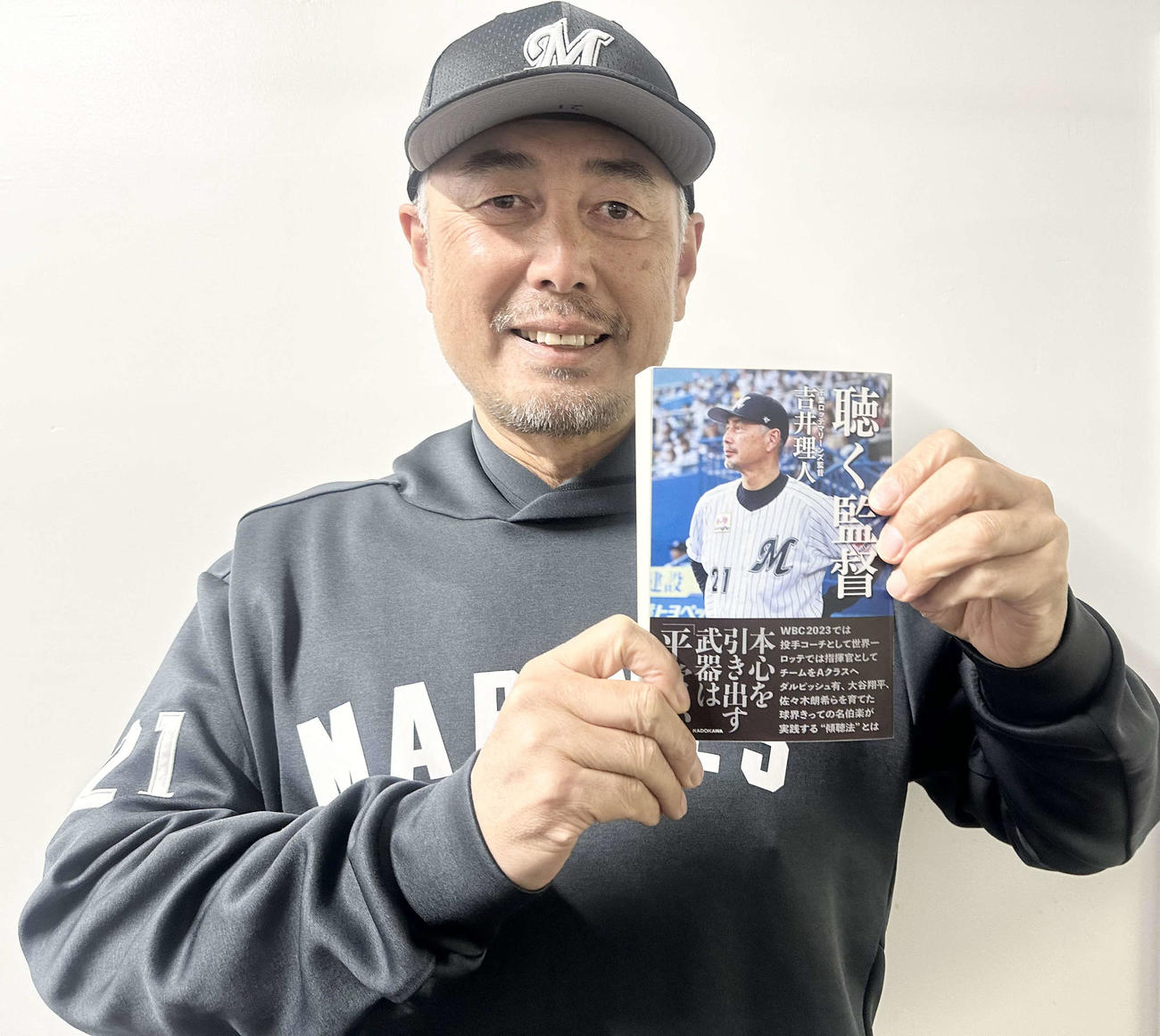 自身の著書を手に笑顔の吉井監督（球団提供）