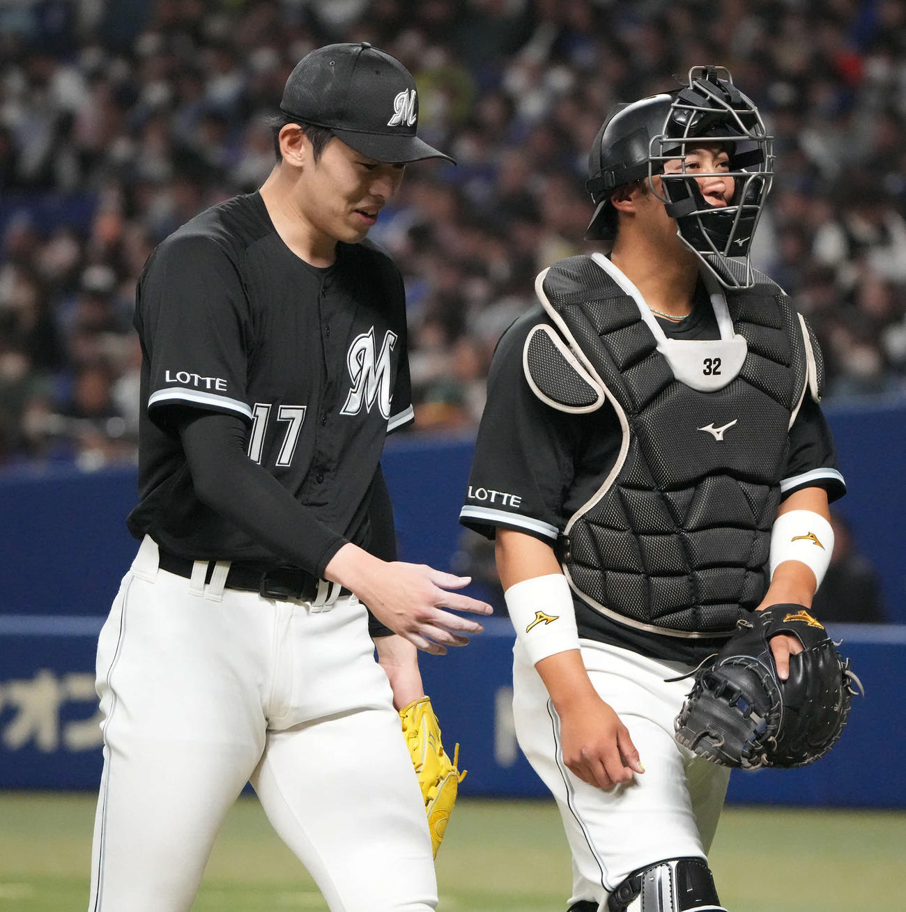 オープン戦の対中日戦で、佐々木朗希（左）と話しながらベンチに戻る佐藤都志也（2024年3月24日撮影）